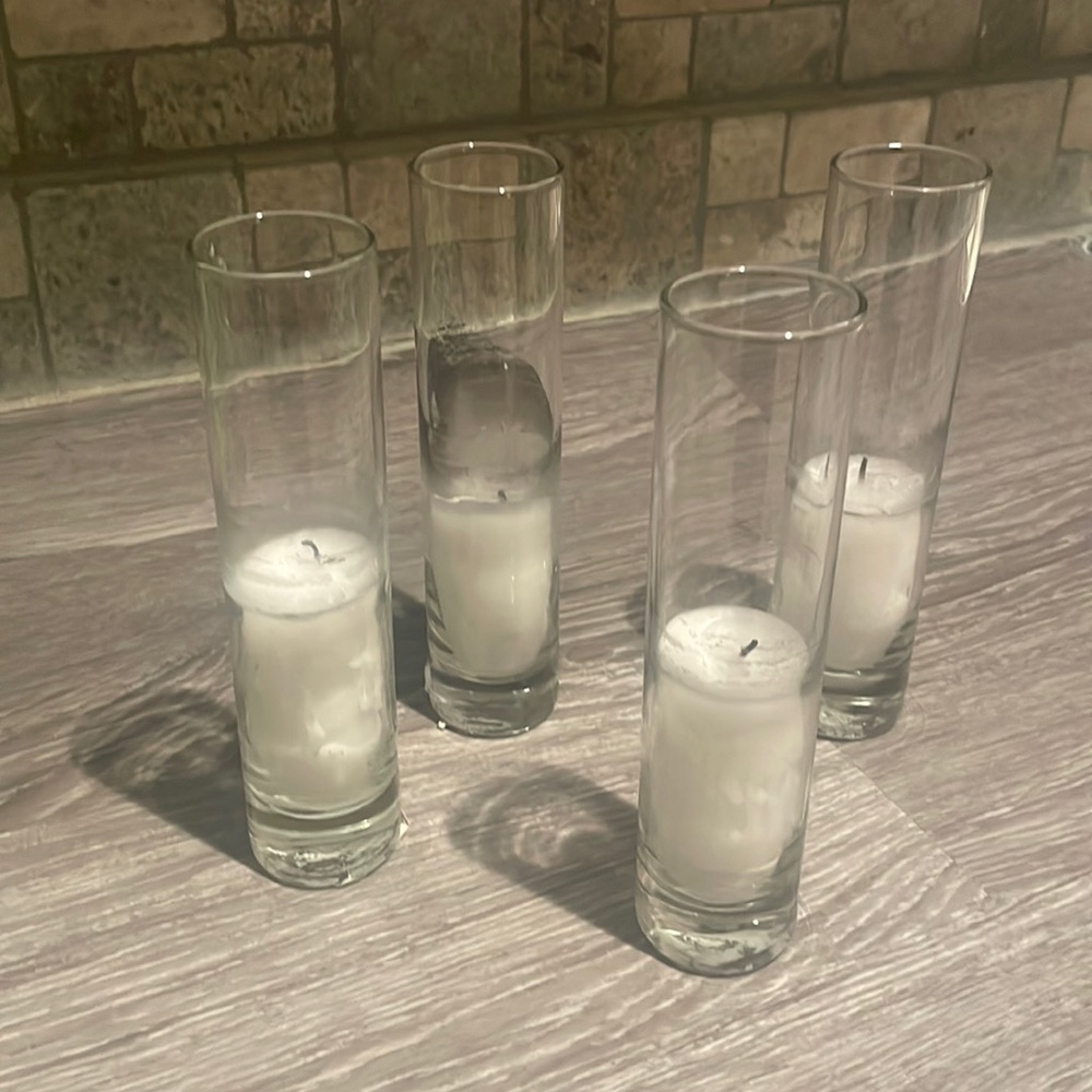 Set of 4 glass pillar candles with candles inside.